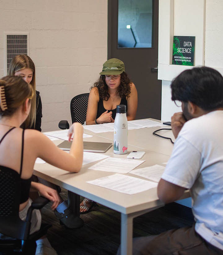 students working around a table in a classroom