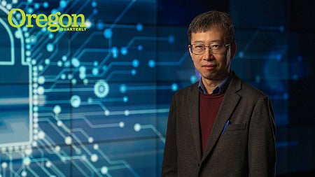 A man stands in front of a graphic of computer code