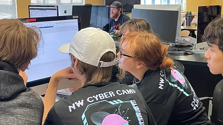 High school students gather around a computer screen