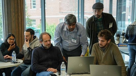 A group of people clustered around a computer screen