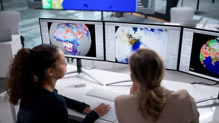 student and teacher sitting in front of computer monitors looking at images