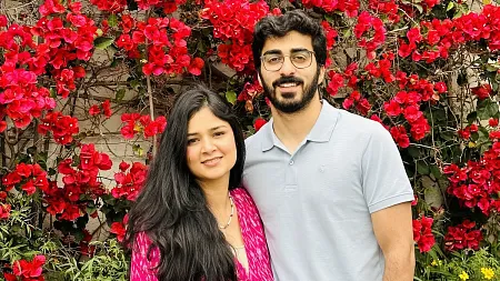 Aliza Lisan and Hammad Ather smiling in front of pink flowers