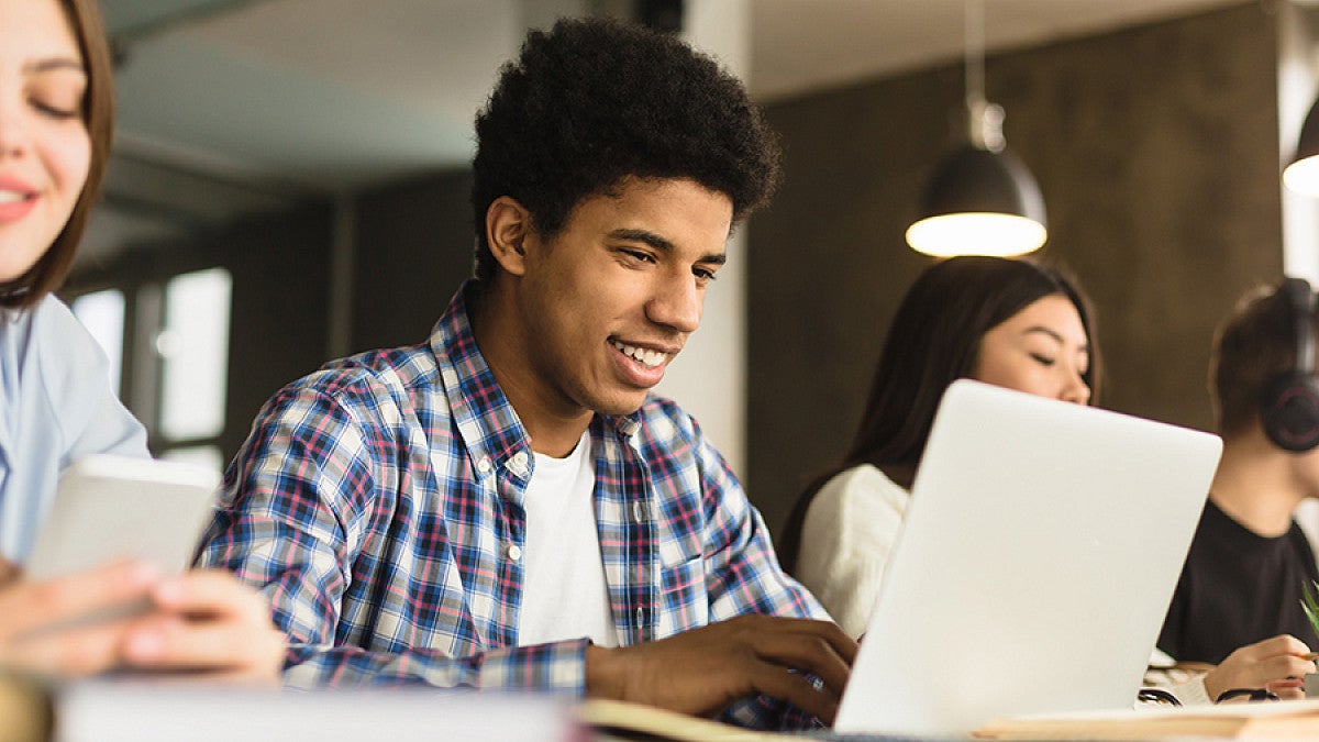 Student working on laptop in classroom