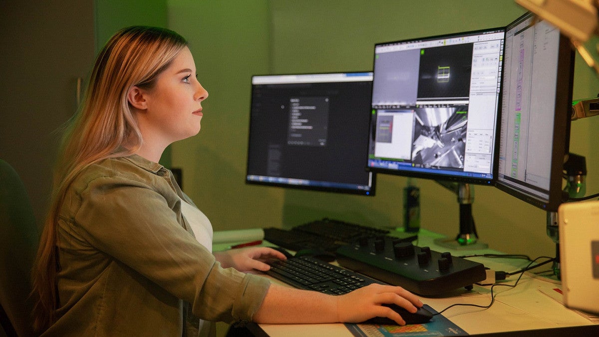 A girl looking at a screen displaying bioinformatics data.