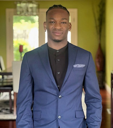 young man with suit jacket buttoned smiled for camera