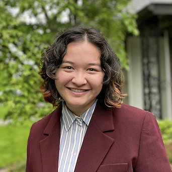 person wearing suit in outdoor setting smiling