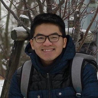 person in outerwear with snowy outdoor background smiling